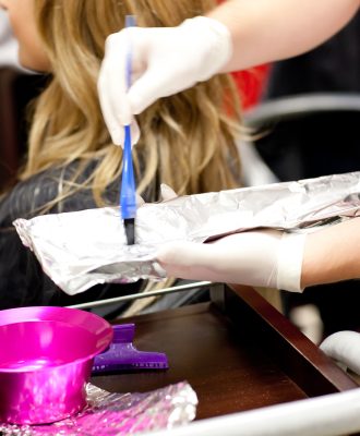 Close-up of a female customer dying her hair in a hairdressing salon